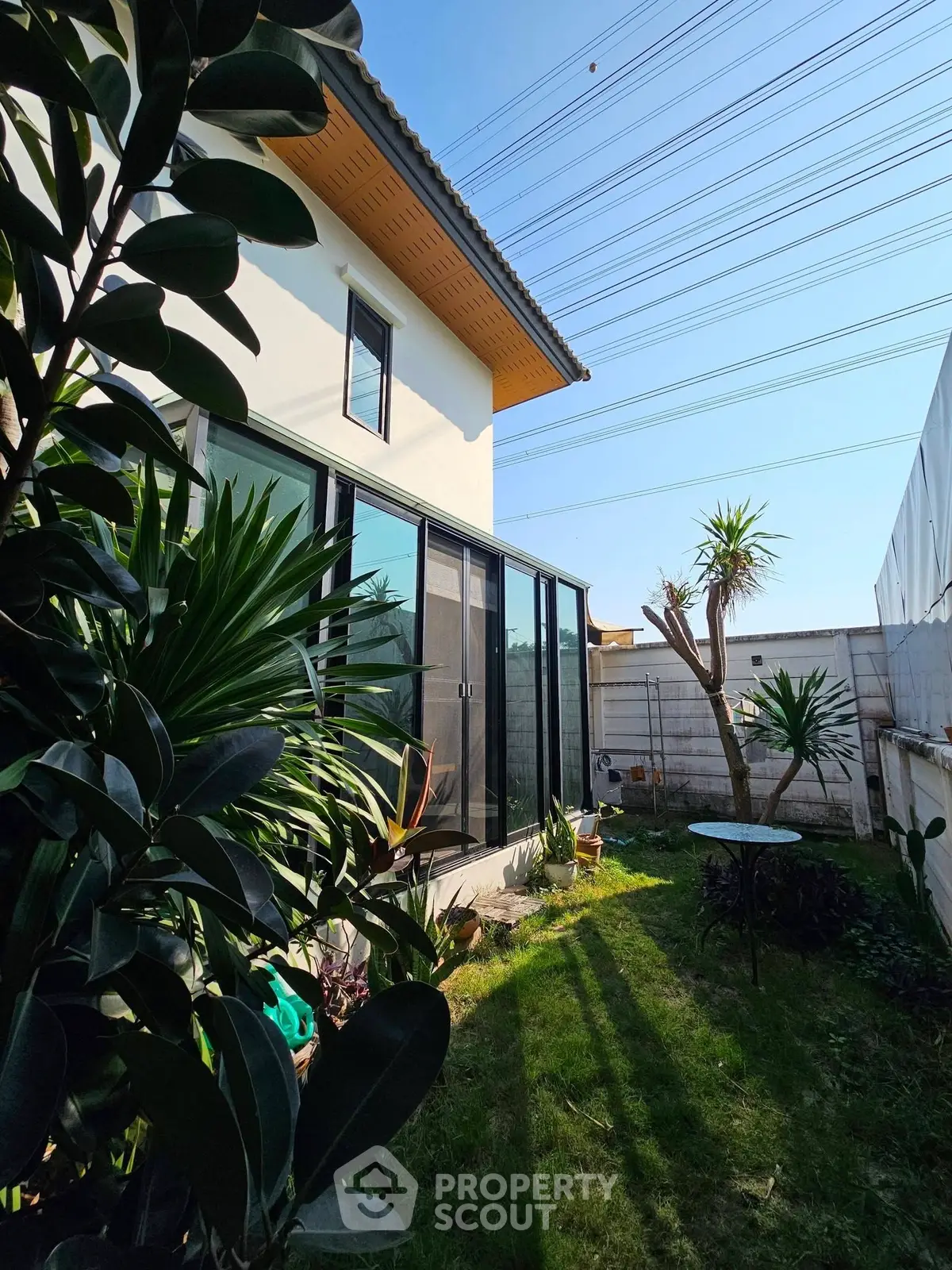 Charming garden view of modern home with lush greenery and large windows