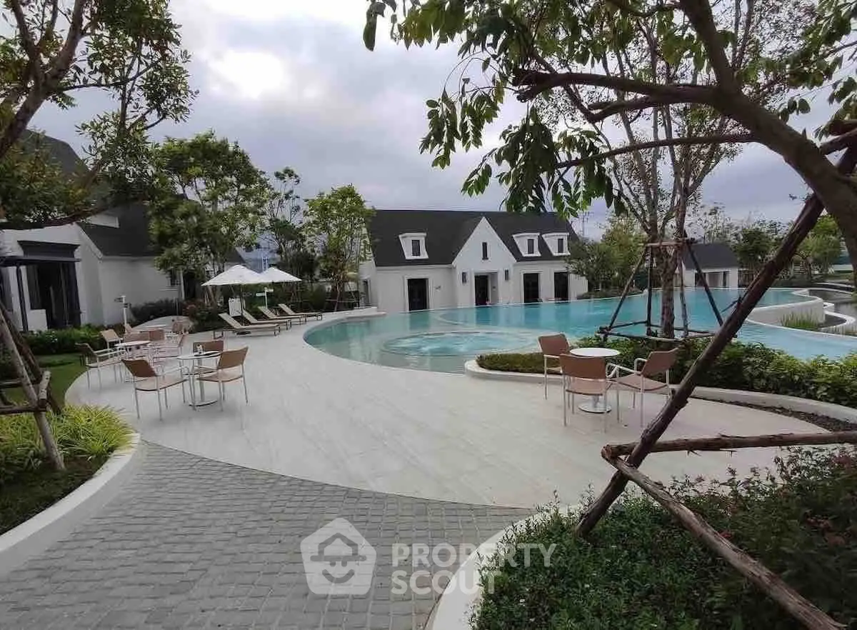 Luxurious poolside view with modern architecture and lush greenery in a serene setting.