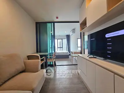 Modern living room with cozy seating and view into a stylish bedroom, perfect for urban living.
