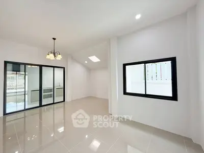 Spacious modern living room with large windows and elegant lighting