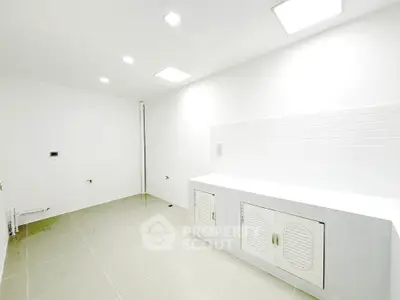 Spacious white kitchen with modern cabinetry and tiled backsplash