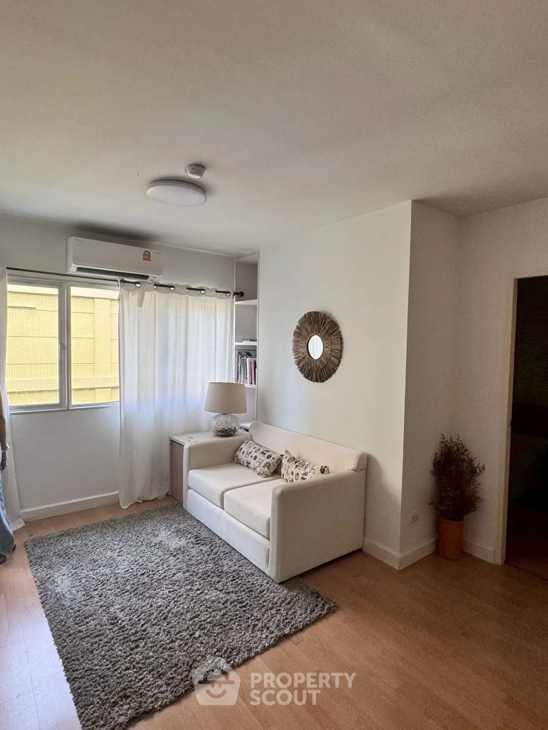 Cozy living room with natural light, featuring a plush sofa and stylish decor.