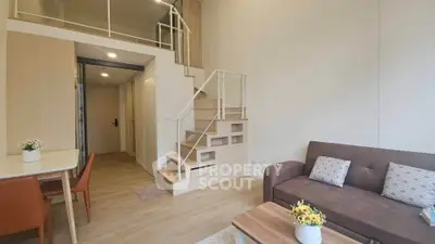 Modern loft apartment with stylish interior, featuring a cozy living area and elegant staircase.