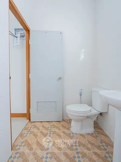 Modern bathroom with geometric tile flooring and white fixtures