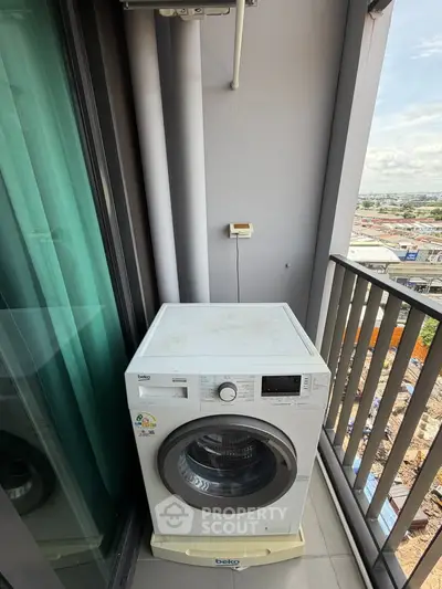 Compact balcony with washing machine and city view, ideal for urban living convenience.