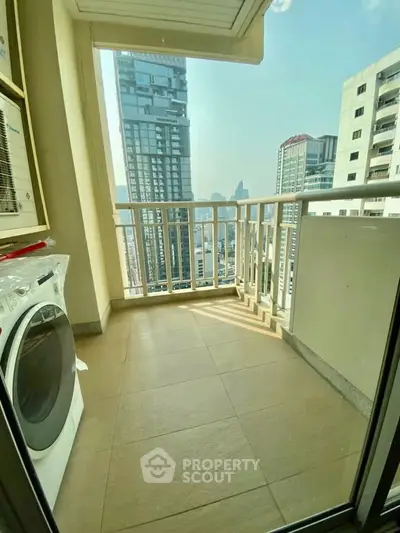 Spacious balcony with city view and washing machine in modern high-rise apartment.