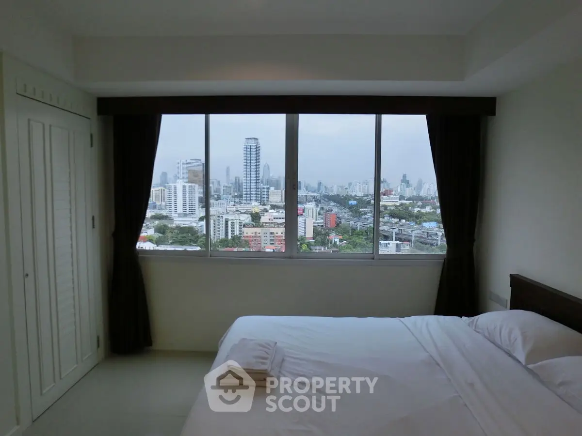 Spacious bedroom with stunning city view through large windows