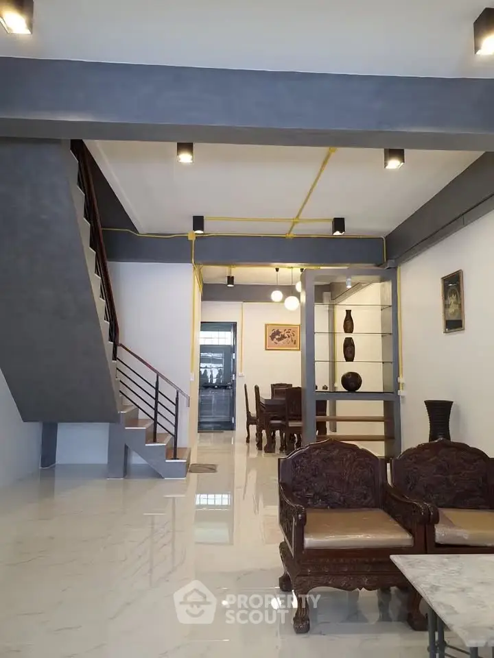 Spacious modern living room with elegant staircase and dining area