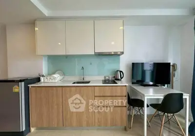 Modern compact kitchen with dining area, featuring sleek cabinetry and contemporary appliances.