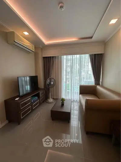 Modern living room with sleek furniture and large window, featuring a cozy sofa and entertainment center.