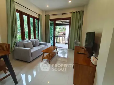 Charming living room with large windows and garden view, featuring modern furniture and elegant decor.