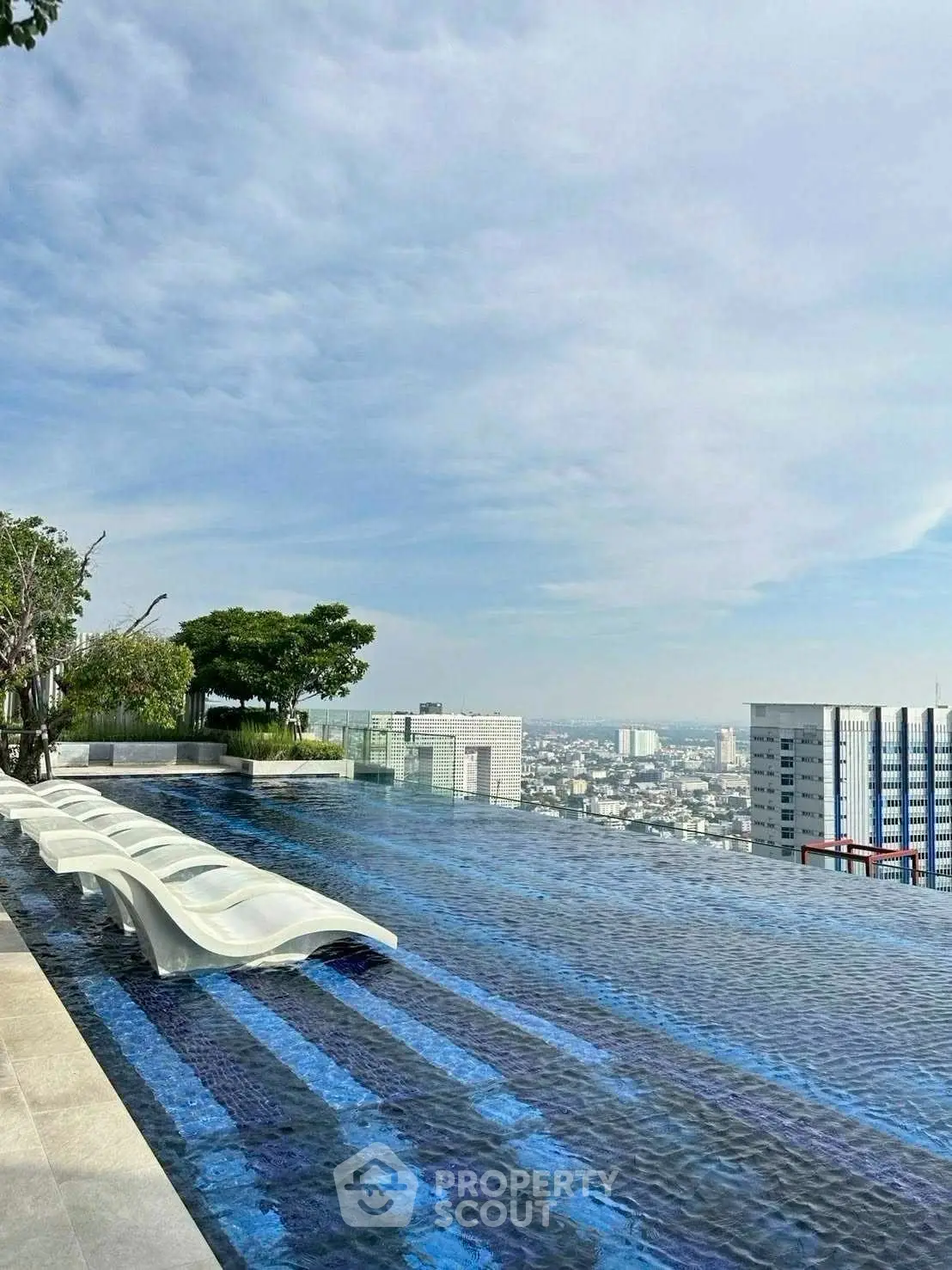 Stunning rooftop infinity pool with panoramic city views and modern lounge chairs.
