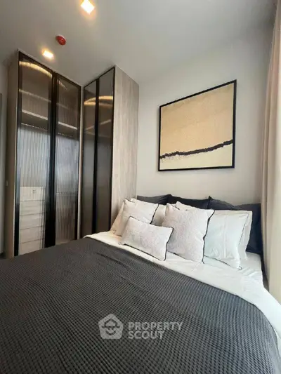 Modern bedroom with stylish decor and cozy bedding in a contemporary apartment.