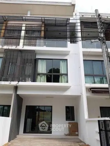 Modern multi-story townhouse with large windows and sleek design