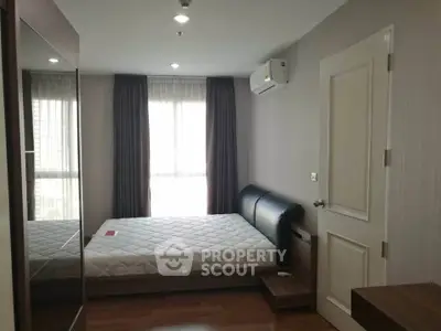 Modern bedroom with large window and air conditioning in a stylish apartment.