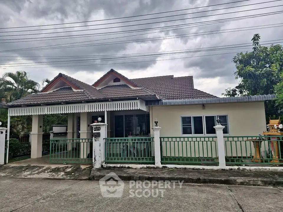 Charming single-story house with tiled roof and fenced yard, perfect for family living.