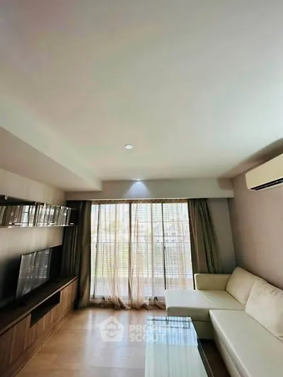 Spacious living room with modern decor and large window for natural light.