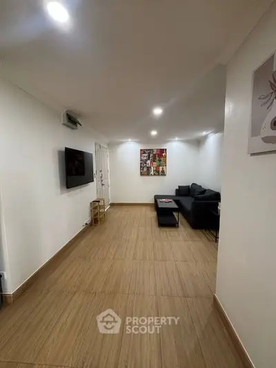 Spacious living room with modern decor and wall-mounted TV, perfect for relaxation and entertainment.