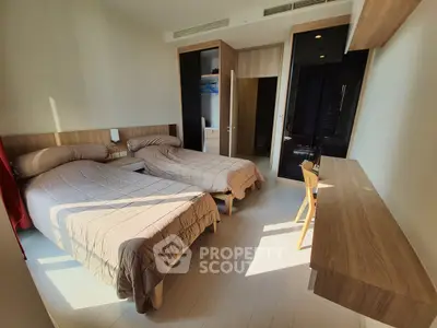 Spacious bedroom with twin beds and modern wooden furniture, perfect for comfortable living.