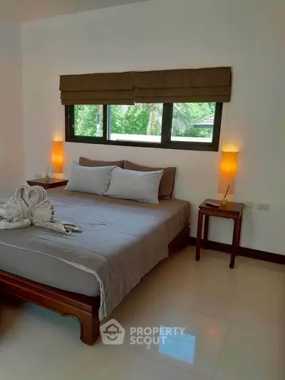 Cozy bedroom with elegant decor and natural light, perfect for relaxation.