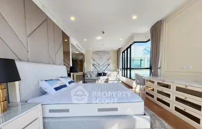 Luxurious bedroom with elegant decor and large windows offering natural light and city views.