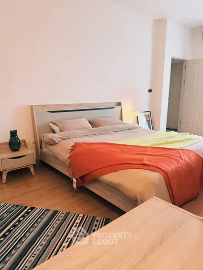 Cozy bedroom with modern decor and vibrant accents in a stylish apartment.