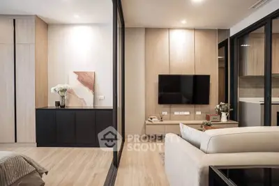 Modern living room with sleek design, featuring a wall-mounted TV, stylish decor, and open layout.