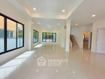 Spacious modern living room with large windows and glossy tile flooring