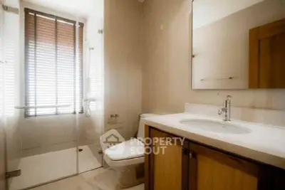 Modern bathroom with glass shower and wooden cabinetry