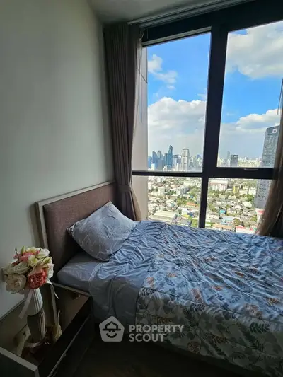 Luxurious bedroom with stunning city view from high-rise apartment, featuring elegant decor and large windows.