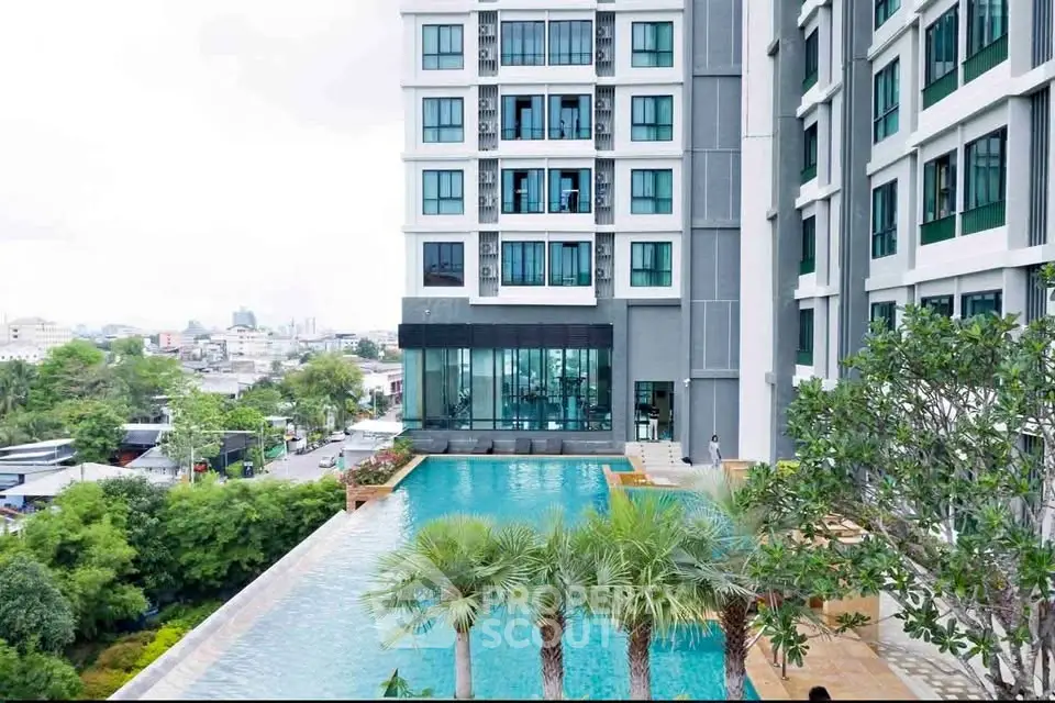 Luxurious high-rise building with stunning pool and lush greenery, offering a serene urban oasis.