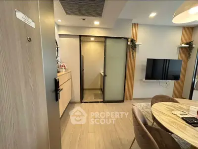 Modern apartment interior with open living and dining area, featuring sleek furniture and stylish decor.