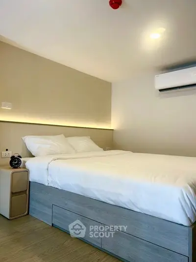 Modern bedroom with sleek design and air conditioning unit.