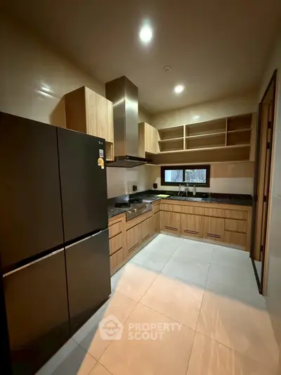 Modern kitchen with sleek black appliances and wooden cabinetry