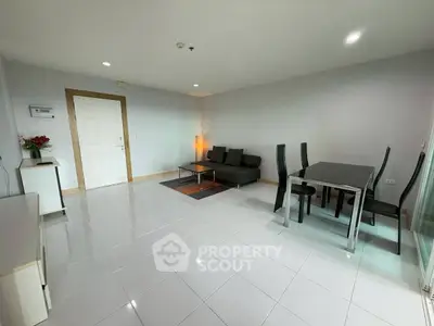 Spacious modern living room with sleek furniture and tiled flooring in a contemporary apartment.