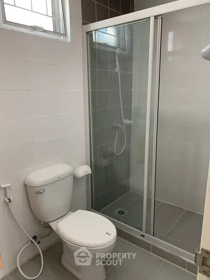 Modern bathroom with glass shower and white tiles, ideal for contemporary living.