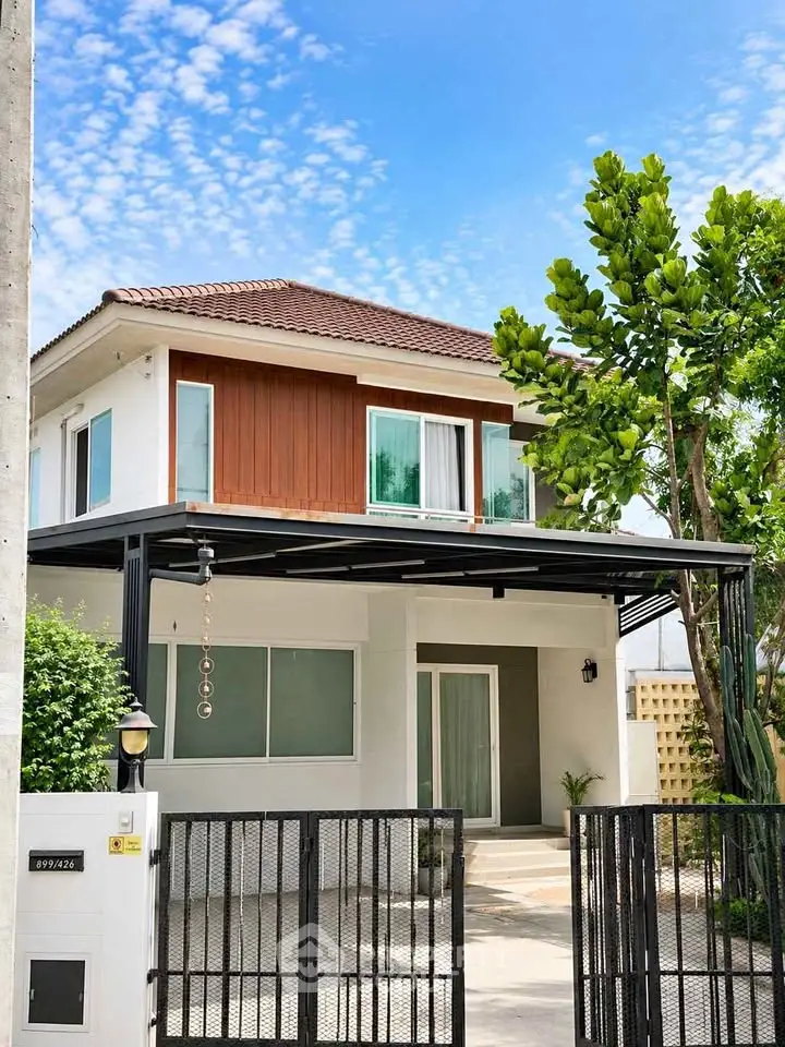Charming two-story house with modern design and lush greenery, perfect for family living.