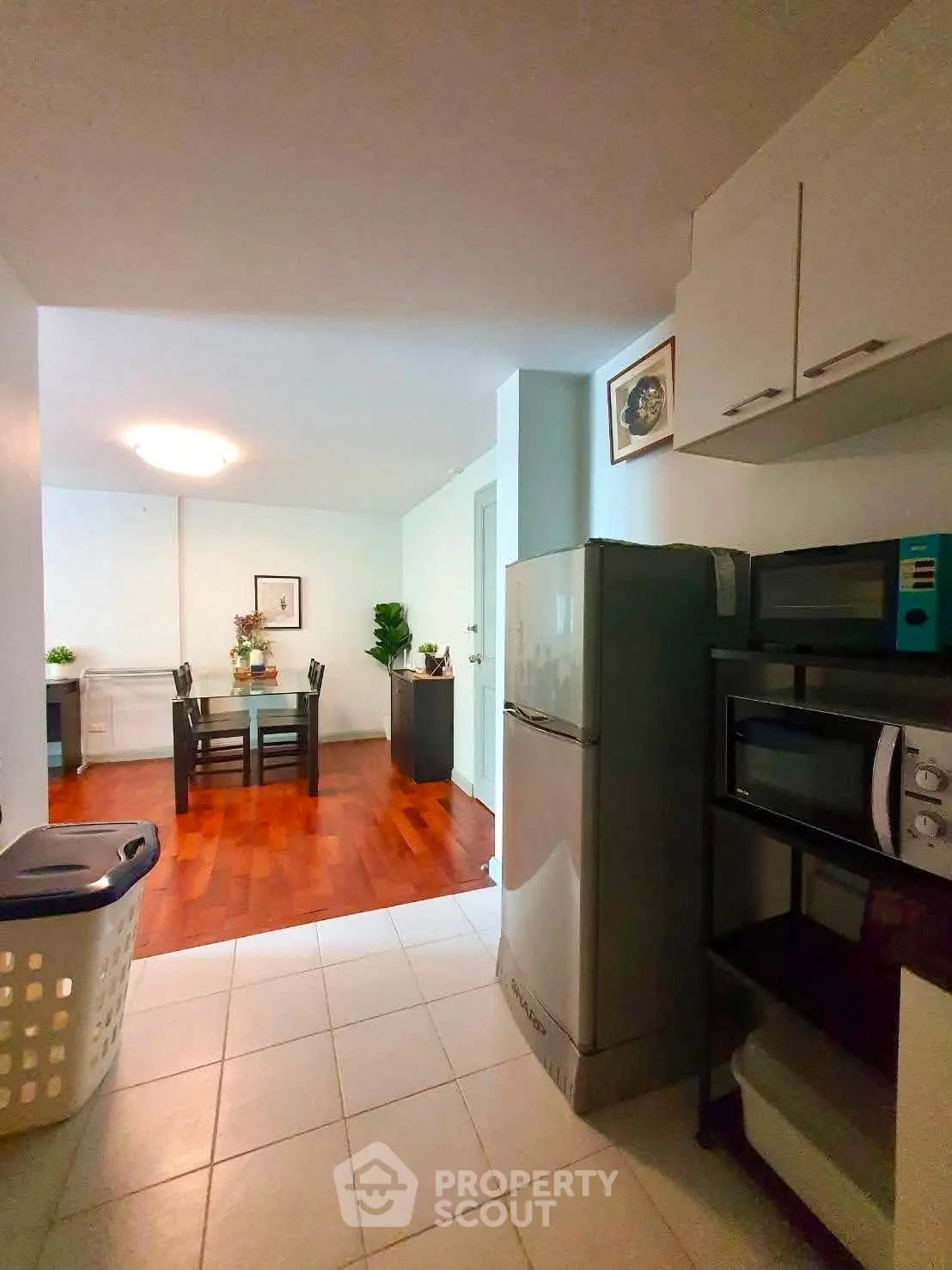 Spacious kitchen with modern appliances leading to a cozy dining area with wooden flooring.