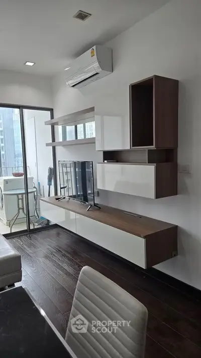 Modern living room with sleek furniture and balcony view in a high-rise apartment.