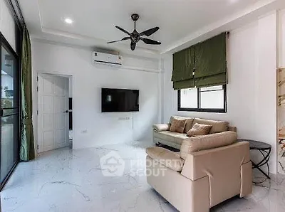 Modern living room with sleek marble flooring, stylish ceiling fan, and cozy seating area.