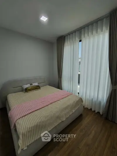 Cozy bedroom with elegant curtains and soft lighting, perfect for relaxation.
