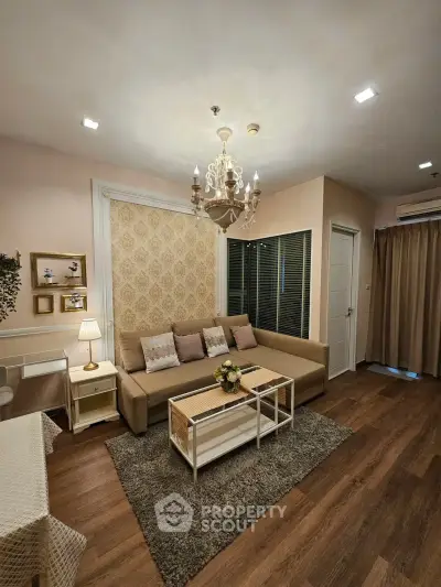 Elegant living room with chandelier, cozy sofa, and stylish decor in modern apartment.