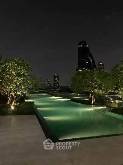 Luxurious rooftop pool with stunning city skyline view at night, perfect for relaxation and leisure.