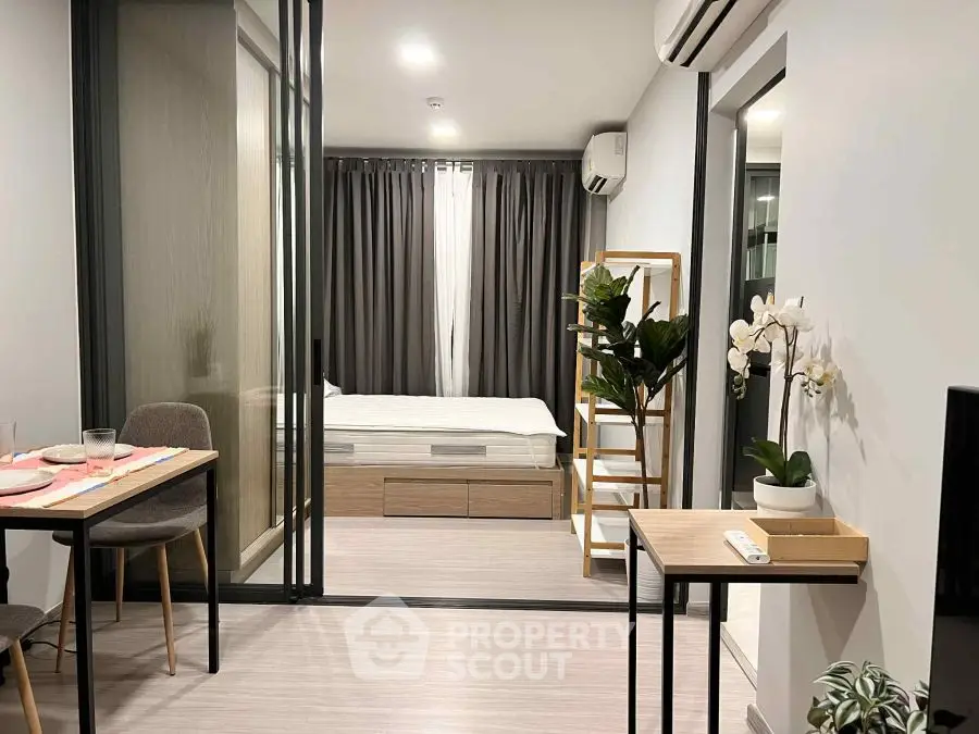Modern studio apartment with stylish decor and open layout, featuring a cozy bedroom and dining area.