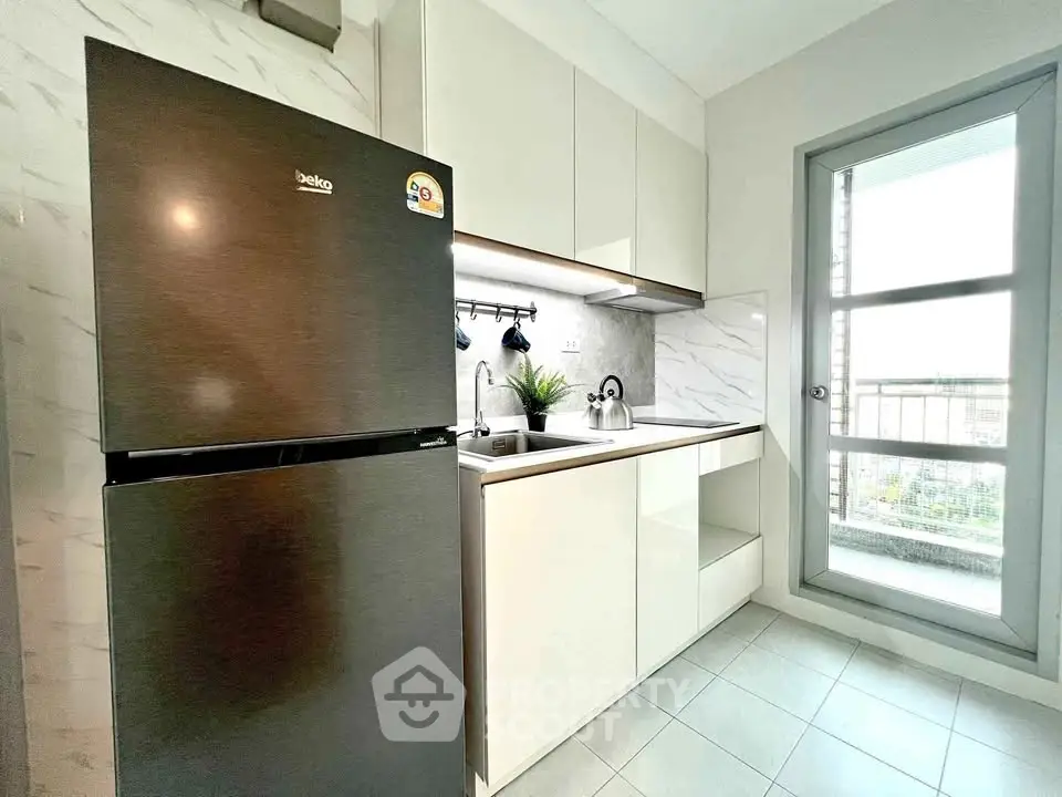 Modern kitchen with sleek appliances and balcony view in a stylish apartment.