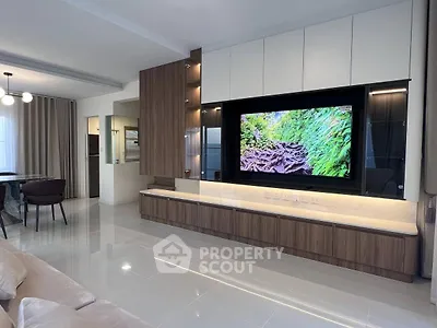 Modern living room with sleek TV setup and elegant dining area