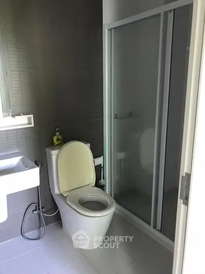 Modern bathroom with sleek design featuring a shower and toilet in a compact space.