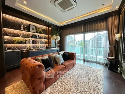 Luxurious living room with plush sofa, elegant decor, and large windows overlooking a serene view.