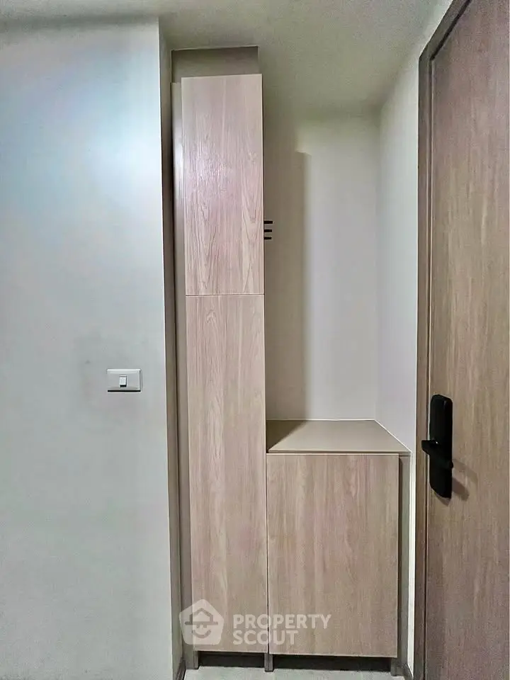 Compact storage unit in modern apartment hallway with wooden finish and sleek design.
