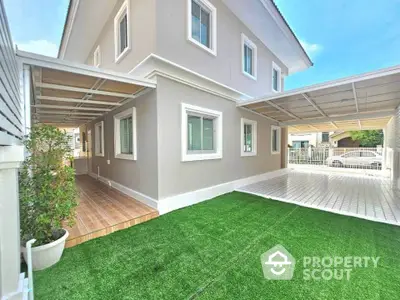 Modern two-story house with spacious carport and artificial grass lawn